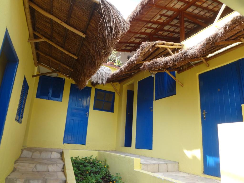 a yellow and blue building with blue doors at Pousada B & B in Águas de Lindoia