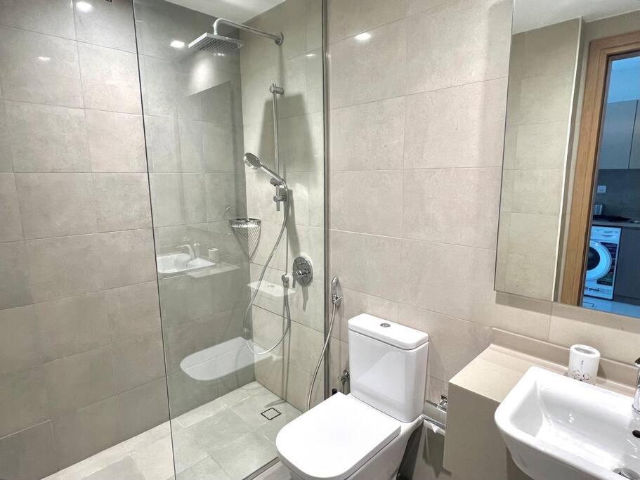 e bagno con doccia, servizi igienici e lavandino. di Fabulous Burj View by Smart Apt a Dubai