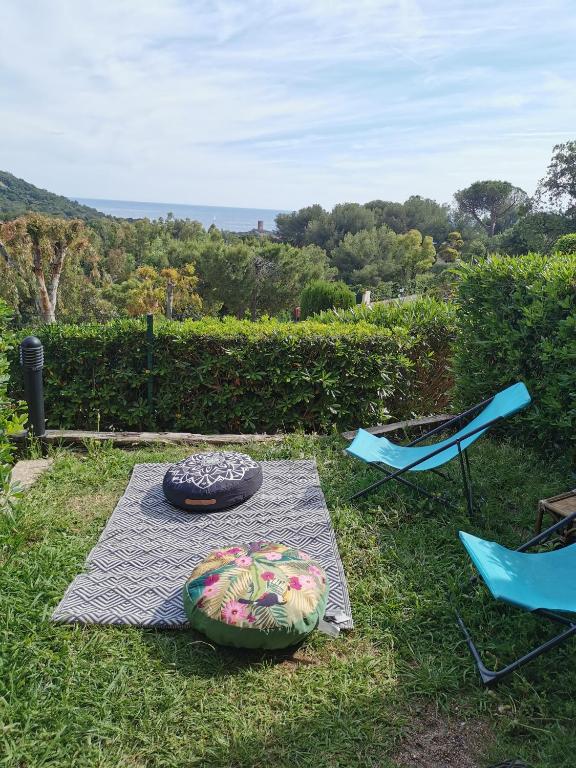 Deux chaises, une table et un pneu sur l'herbe dans l'établissement Cap Esterel Ile d'or dans Village de vacances, à Saint-Raphaël