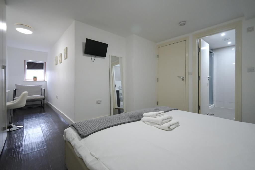 una camera bianca con letto e televisore di Charlotte Street Rooms by News Hotel a Londra