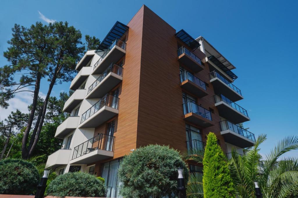 un edificio de apartamentos con balcones y árboles en Ritsa Resort en Ureki