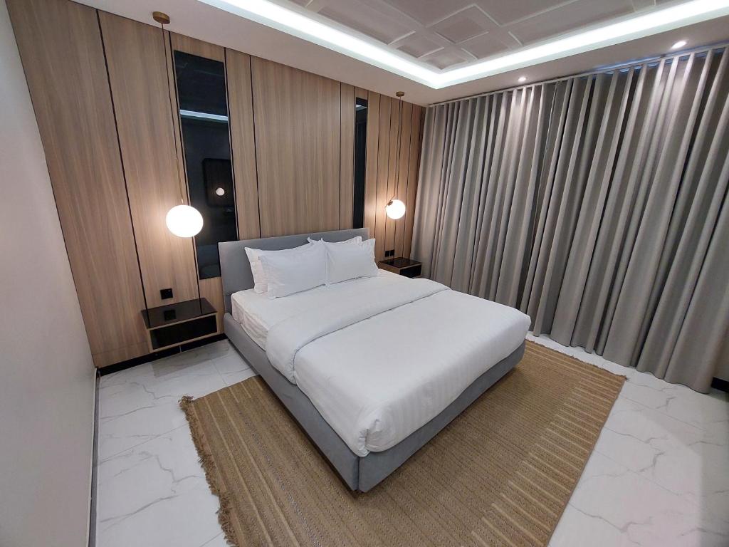 1 cama blanca grande en una habitación con ventana en Elite House en Taif