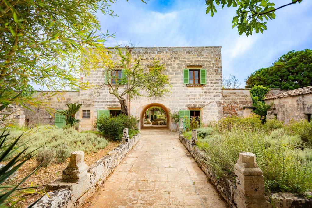 uma vista exterior de um edifício de pedra com um arco em Masseria Casino Mattia em Surano