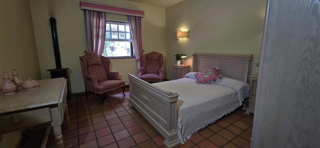 - une chambre avec un lit, deux chaises et une fenêtre dans l'établissement Casa Alameda El Paso, à El Paso