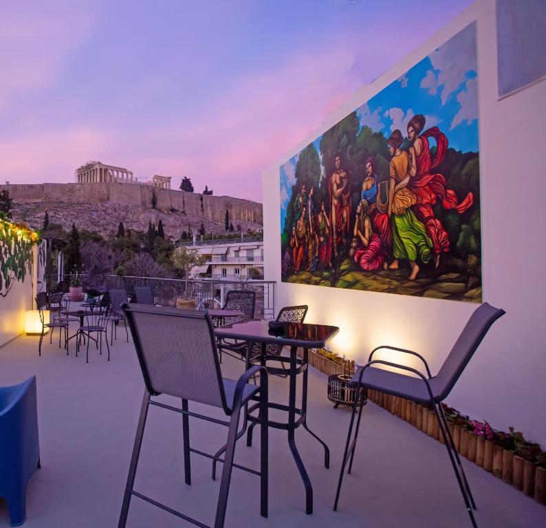 una habitación con mesas y sillas y un cuadro en la pared en Ourania by Heloni Apartments, en Atenas