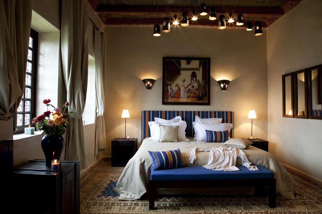 a bedroom with a bed with a blue bench at Kasbah Illy in Demnat