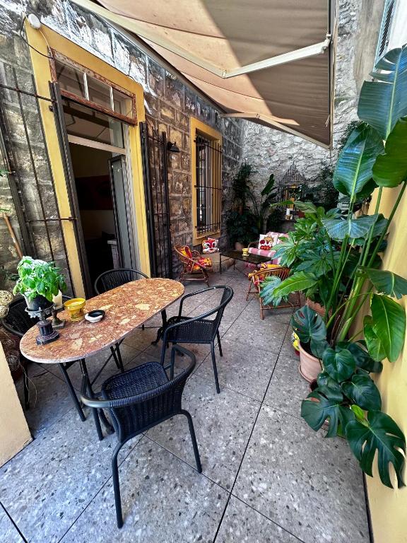 un patio avec une table, des chaises et des plantes dans l'établissement Grand appartement port de Nice, à Nice