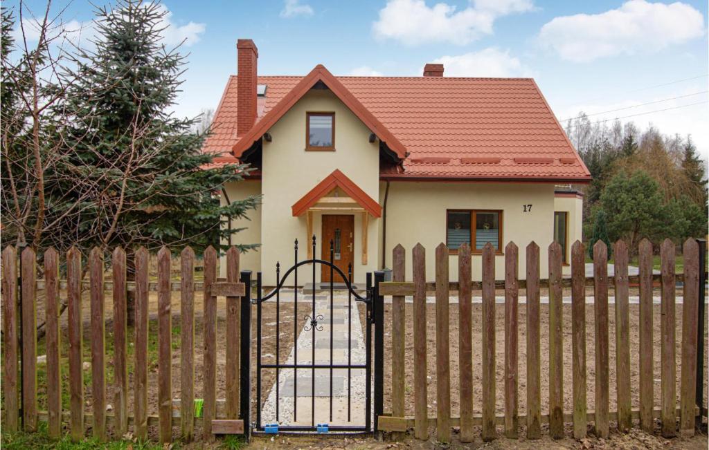 una casa dietro una recinzione di legno con cancello di Amazing Home In Ilawa With Wifi a Iława