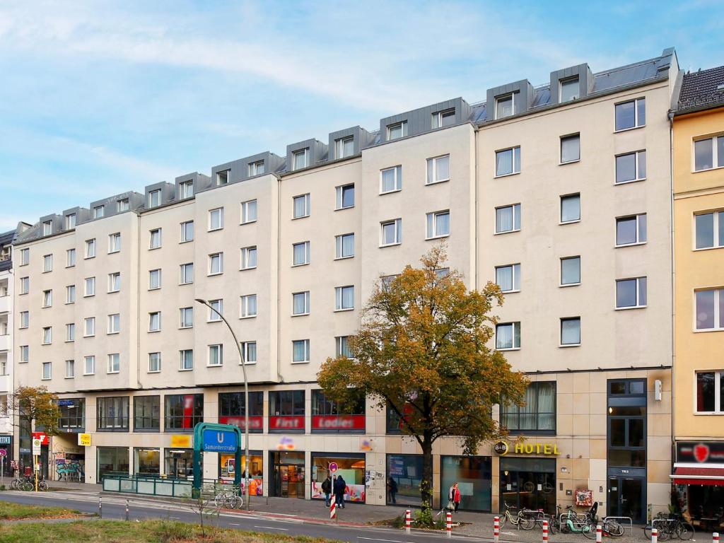 B&B Hotel Berlin City-Ost في برلين: مبنى ابيض كبير على شارع المدينة