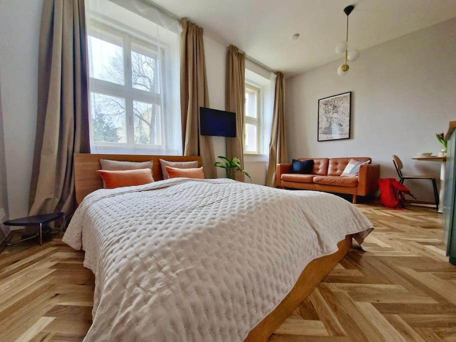 Stylish Studio near Dejvická metro station في براغ: غرفة نوم بسرير كبير وغرفة معيشة