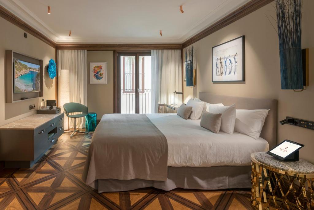 a hotel room with a large bed and a desk at El Llorenc Parc de la Mar - Adults Only (+16) in Palma de Mallorca