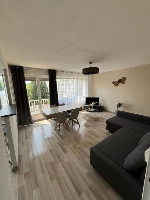 un salon avec un canapé noir et une table dans l'établissement T3 de charme proche du centre, à Douai