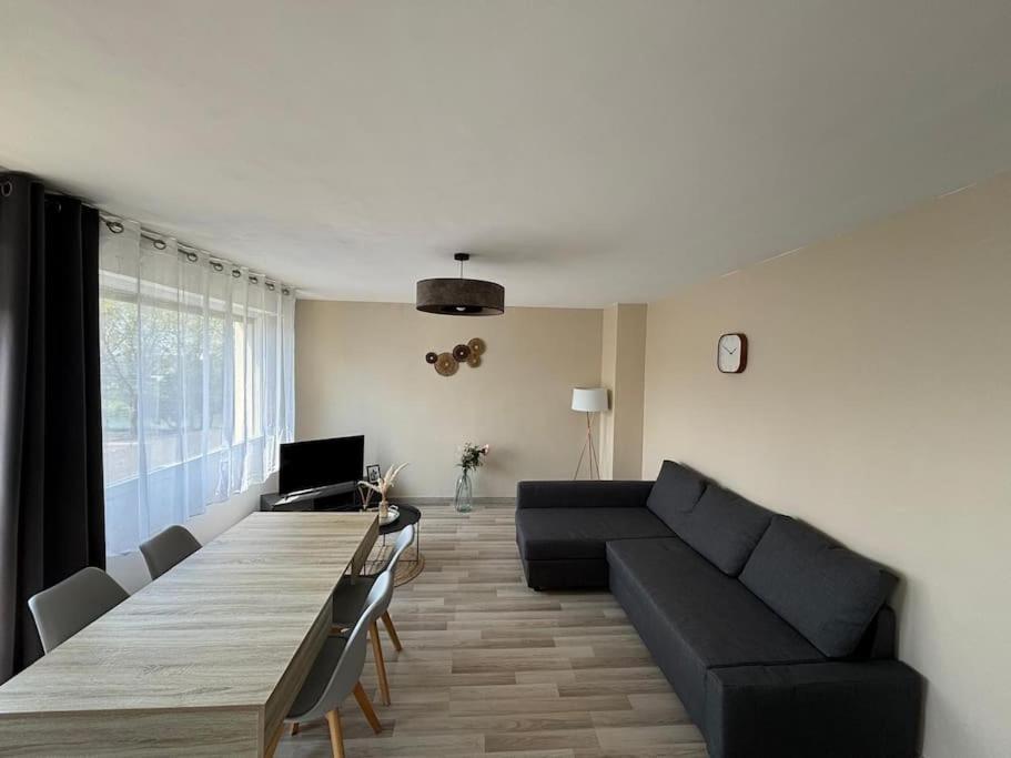 un soggiorno con un lungo tavolo e un divano di T3 de charme proche du centre a Douai