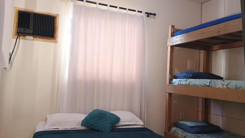 1 dormitorio con 2 literas y ventana en Caminho da Praia - Casa e kitnet en Arraial do Cabo