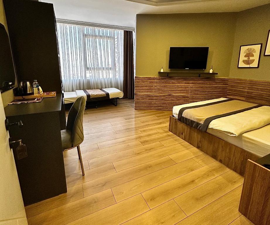 a hotel room with a bed and a flat screen tv at Skymoon Istanbul Airport Hotel in Arnavutköy