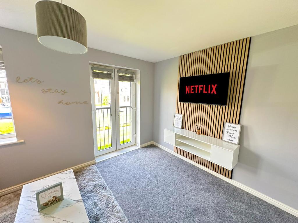 ein Wohnzimmer mit einem Netflix-Logo an der Wand in der Unterkunft Luxury 4 Bed House - Free Parking - Contractors - Relocators in Newcastle upon Tyne