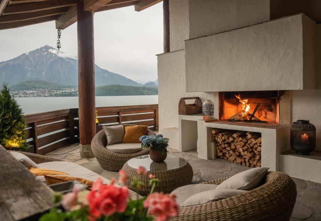 a patio with a fireplace with a view of a mountain at Lakeside Chalet with Panorama View in Thun