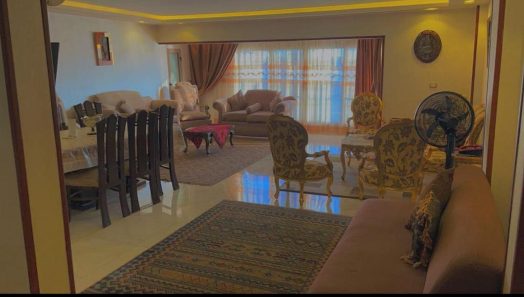 a living room with a couch and a table and chairs at شقة فندقية مميزة بالمنصورة in Ṭalkha