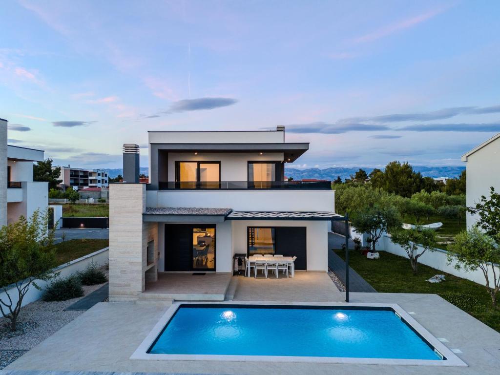ein Haus mit einem Swimmingpool davor in der Unterkunft Villa Marita 2 in Privlaka