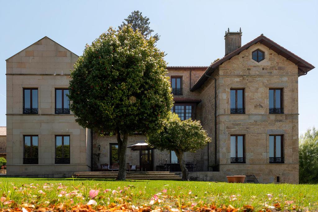 duży kamienny dom z drzewem przed nim w obiekcie Casa dos Maza w mieście Cambados
