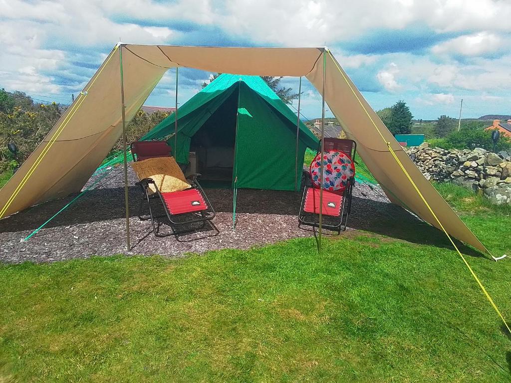 uma tenda verde com cadeiras em frente em Mountain View em Caernarfon