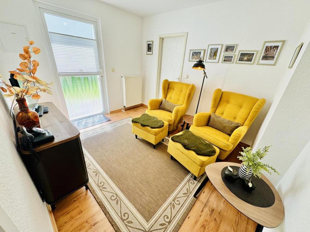 sala de estar con 2 sillas amarillas y TV en Appartement Rosenwinkel, en Warnemünde