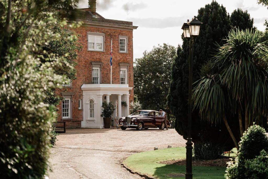 an old car parked in front of a brick building at Highfield Park in Hook