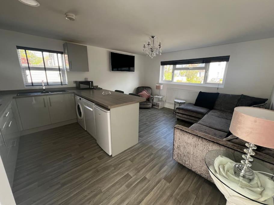 a living room with a couch and a kitchen at Willow Lodge in Dymchurch