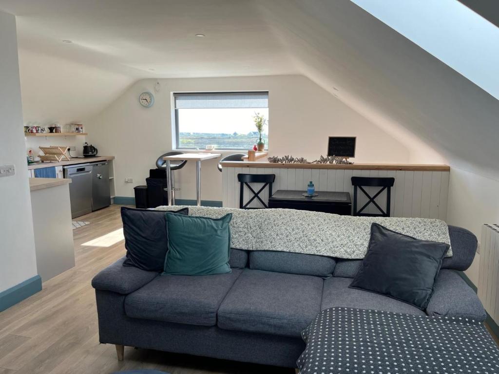 sala de estar con sofá y cocina en Island View Apartment, en Miltown Malbay