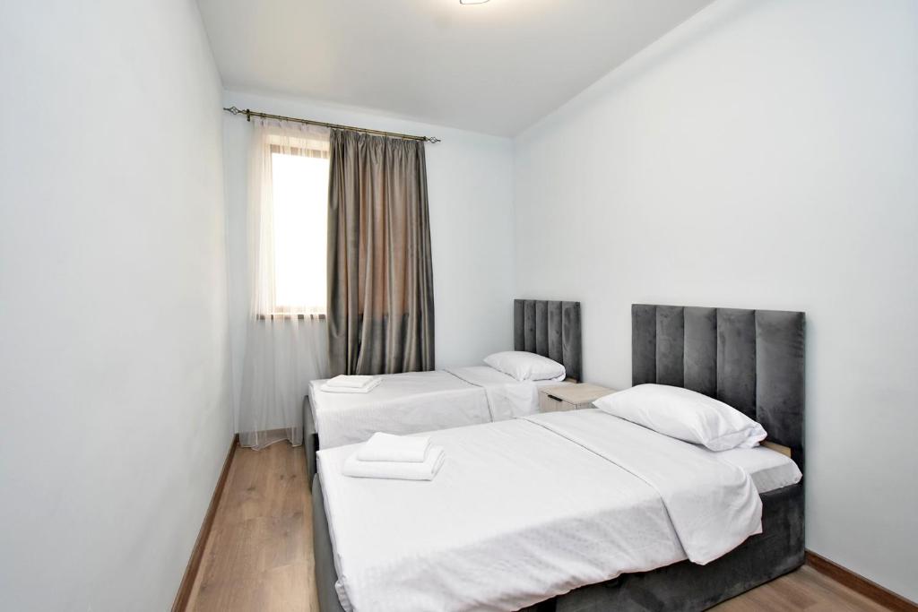 EvnAir في Pʼarakʼar: سريرين في غرفة بجدران بيضاء ونافذة