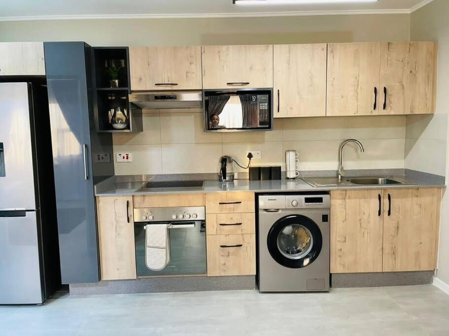 kuchnia z pralką i zmywarką do naczyń w obiekcie Motswedi 1 bedroom apartment B9 w mieście Gaborone