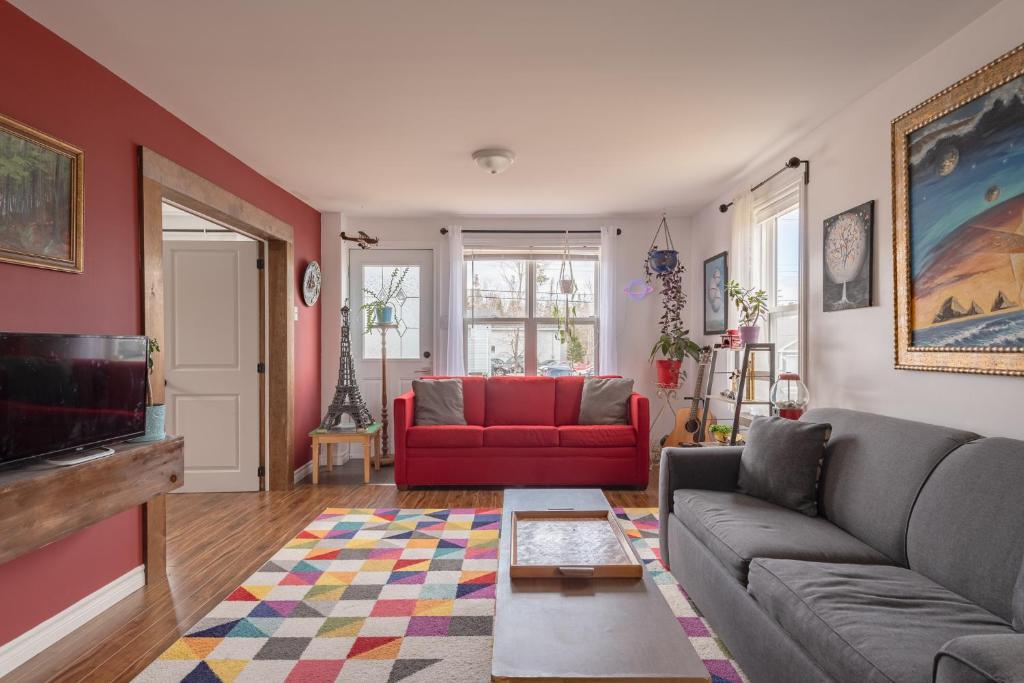 un soggiorno con divano e sedia rossa di The Artbnb a French Village