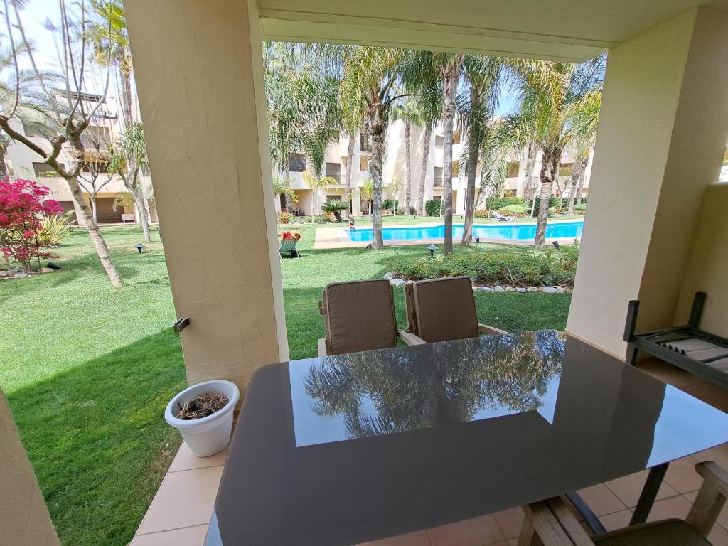 Elle offre une vue sur une terrasse avec une table et des chaises. dans l'établissement Roda Golf gelijkvloers appartement, à Roda