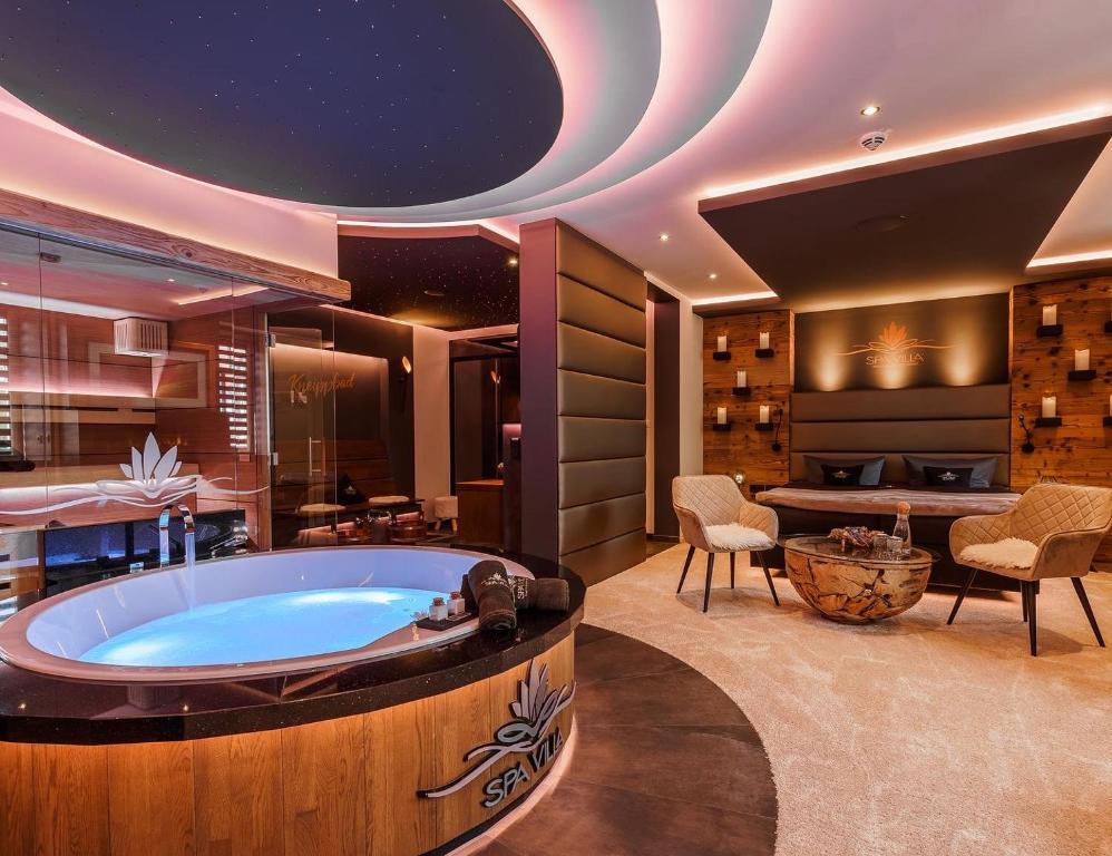 una vasca idromassaggio in una stanza con tavolo e sedie di Spa Villa Beauty & Wellness Resort a Wingerode