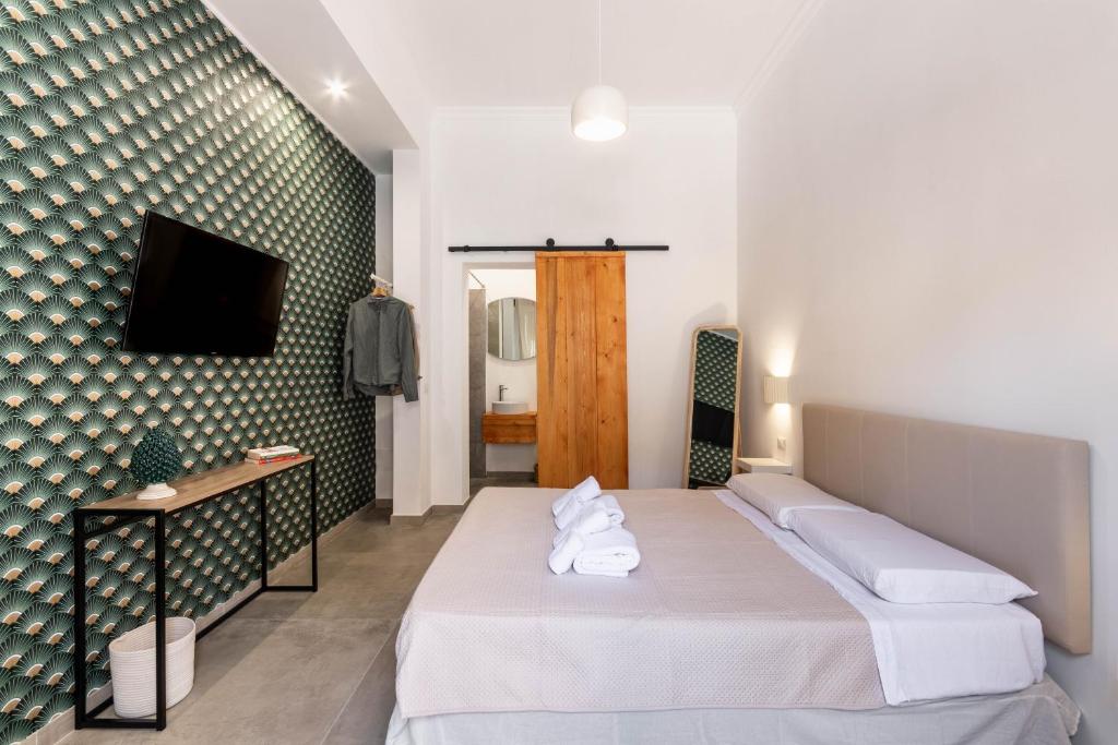 a hotel room with a bed and a tv at Il Moro Rooms in Avola