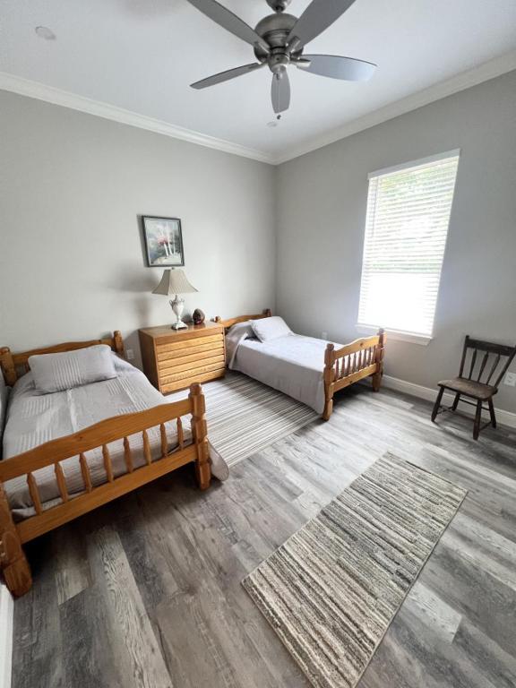 Un dormitorio con dos camas y un ventilador de techo. en Walk or Bike Ride to beach and Centrally located, en Gulfport