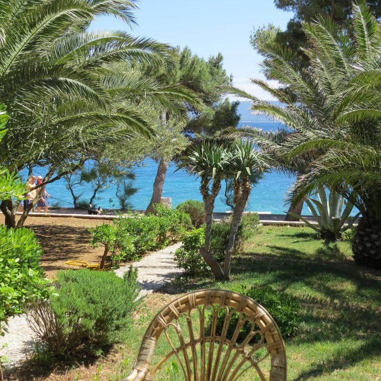 a chair sitting in the grass next to the ocean at Sea House Bol in Bol