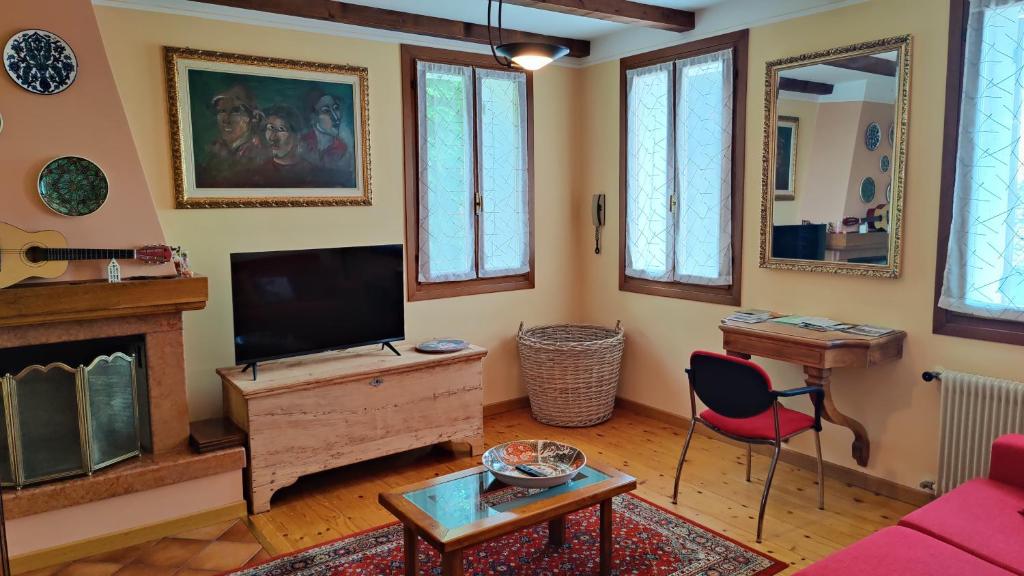sala de estar con TV y chimenea en Casa Vacanze Monte Villa, en Pieve di Soligo