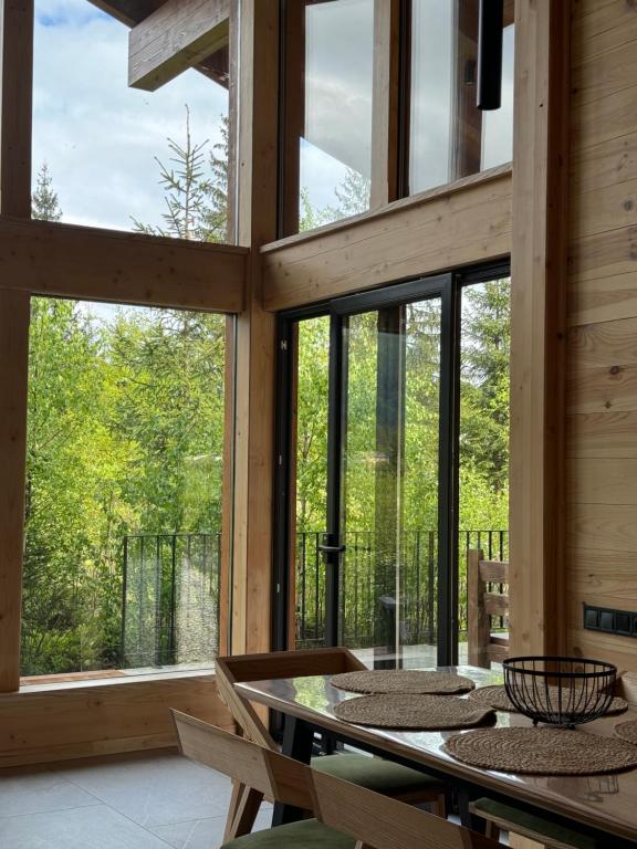 a dining room with large windows and a table at MOKHY Chalet & Nature in Vorokhta
