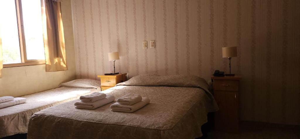 una habitación de hotel con 2 toallas en una cama en Hotel Geminis en Mendoza