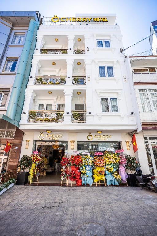 a white building with a flower shop in front of it at CHERRY HOTEL in Da Lat