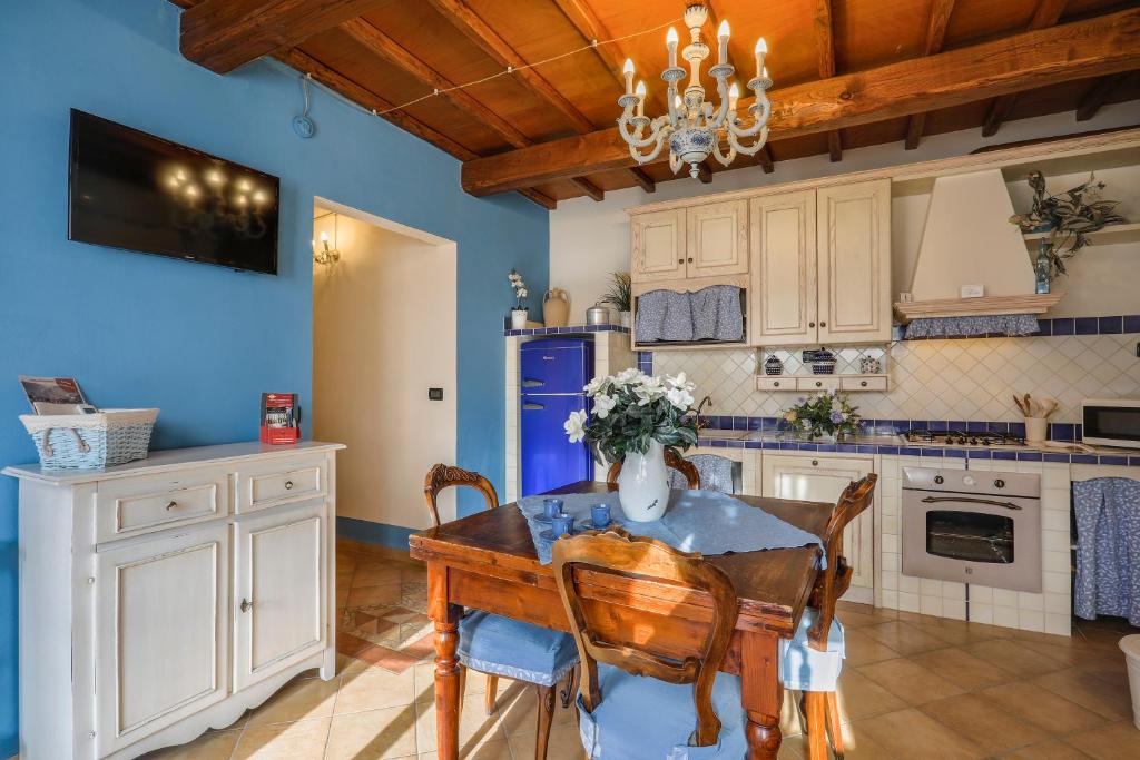 una cucina con tavolo, sedie e frigorifero di MIRTILLO di Home Hill a Lucca