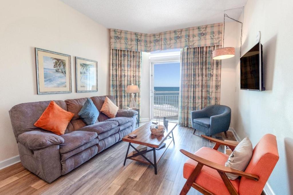 a living room with a couch and a table at Family friendly ocean view condo, beachfront building, pool and wifi included, M in Myrtle Beach