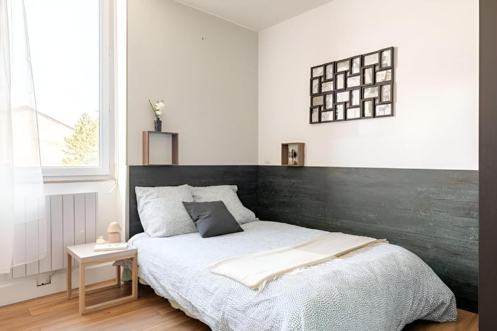 une chambre avec un grand lit avec une tête de lit en bois dans l'établissement Le Jungle Trefilerie Spacieux - équipé - Wifi - TV - Calme, à Saint-Étienne