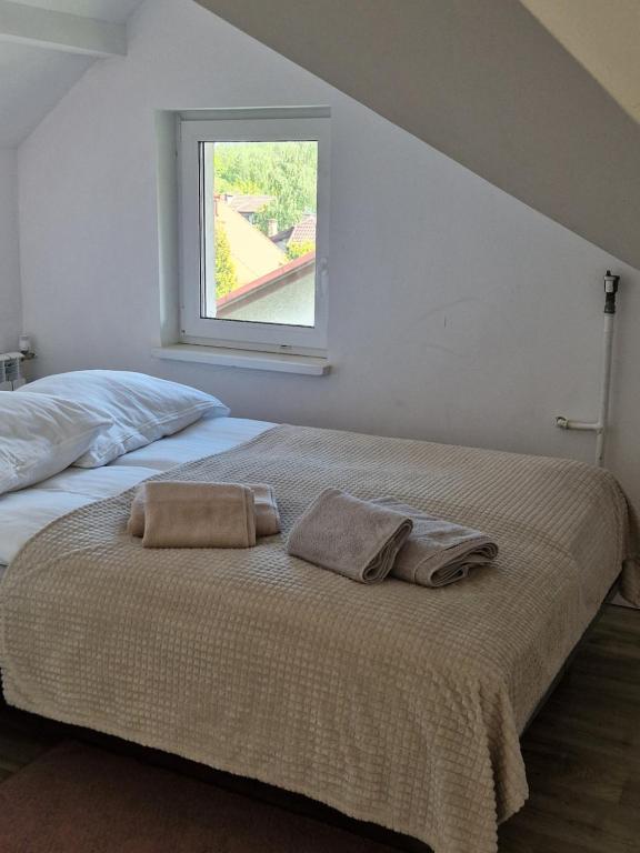 a bedroom with a bed with two towels on it at Little Wish in Gdańsk