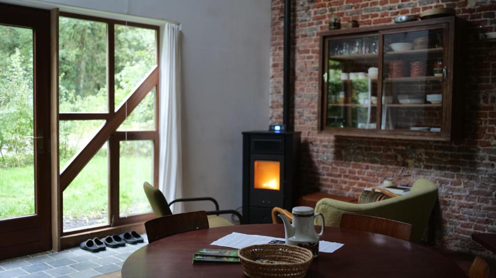 a dining room with a table and a fireplace at Het Bosnest, een vakantiewoning aan het Hallerbos in Halle
