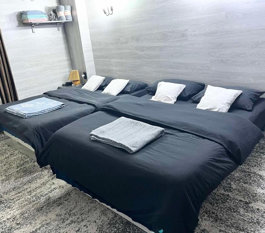 1 cama grande con sábanas azules y almohadas blancas en Империал Хотел, en Chişinău