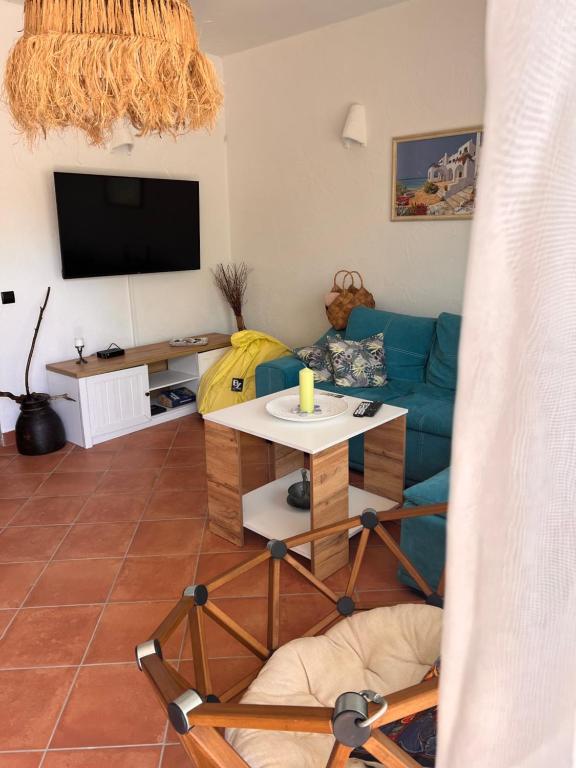 sala de estar con sofá azul y TV en Villa Oasis етаж1 en Lozenets