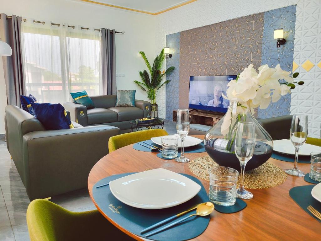 Elegant Appartement BELAPPART في بوانت نوار: غرفة معيشة مع طاولة مع إناء من الزهور