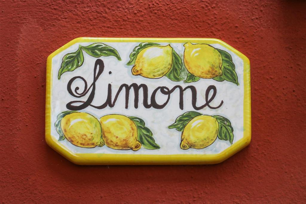 Un cartello con dei limoni su un muro. di LIMONE di Home Hill a Piaggiori